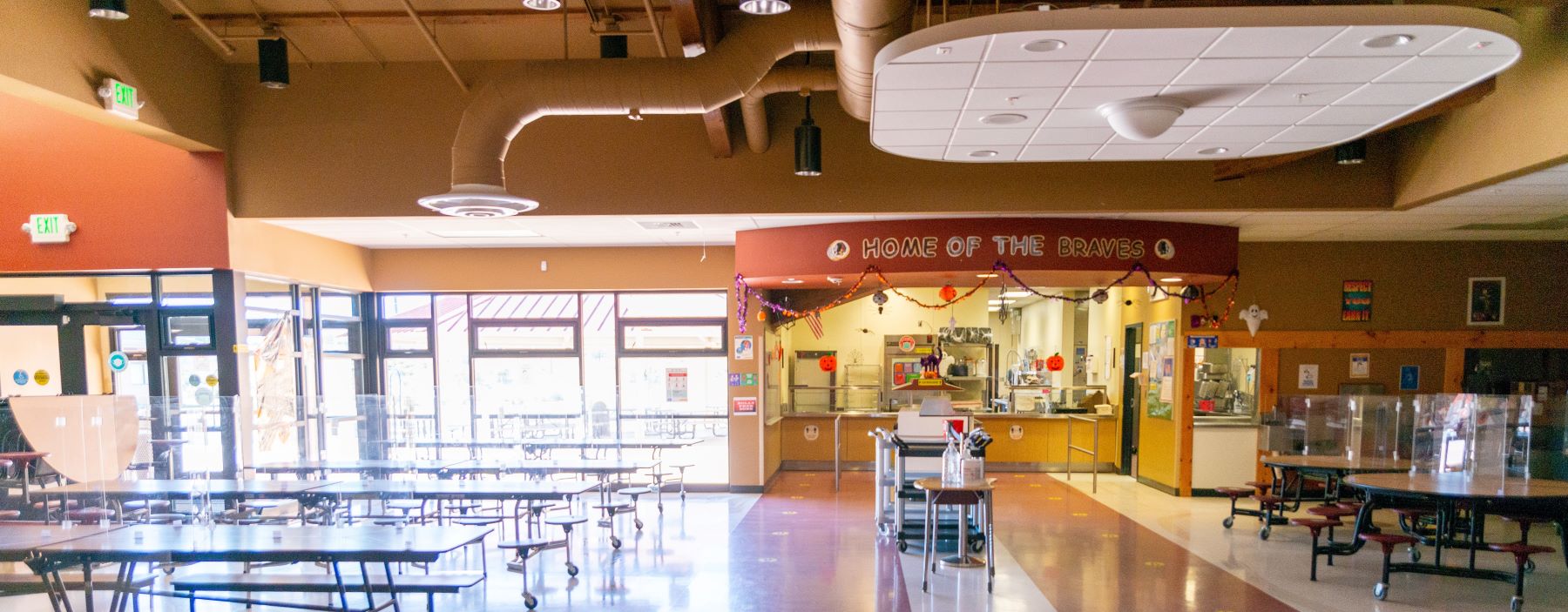 Bright, cheery cafeteria with plenty of tables and food pickup area.