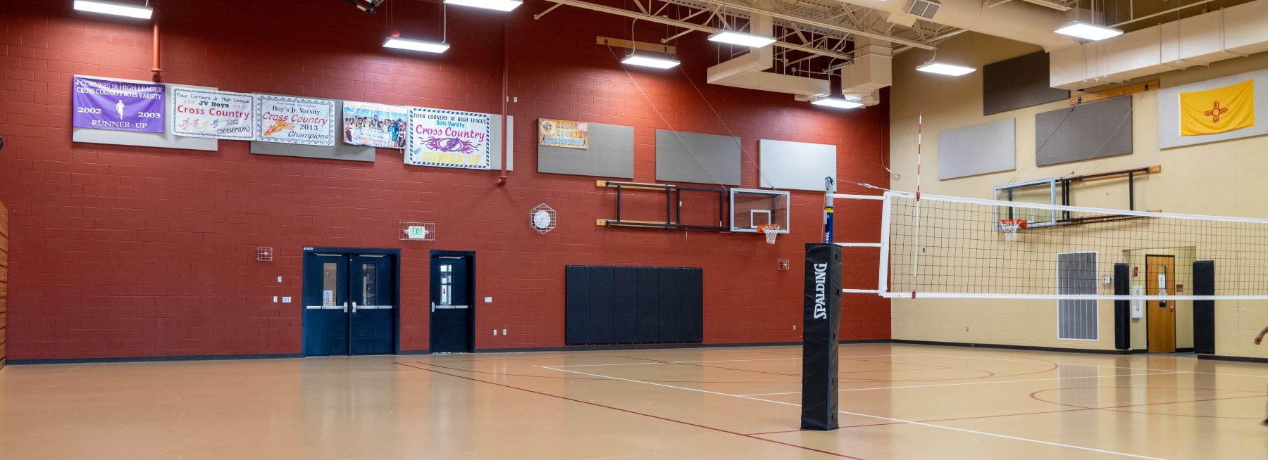 Gymnasium with net and sports banners on the walls.