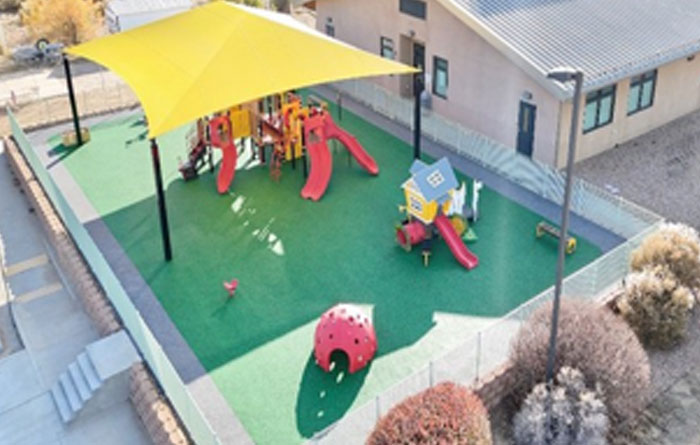 School playground with slides and shade canopy.