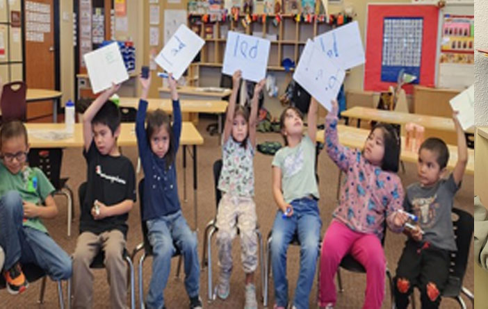 Kindergarten students share spelling words on white paper
