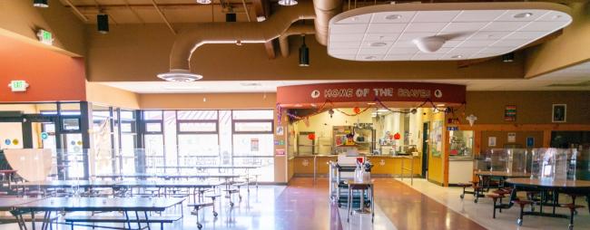 Bright, cheery cafeteria with plenty of tables and food pickup area.